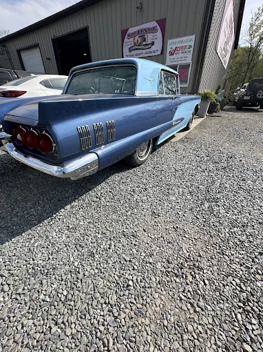 Blue classic car parked beside the Southside shop.