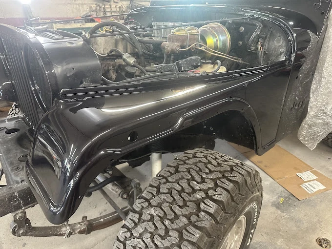 Pickup with a front body panel removed, showing the engine bay.