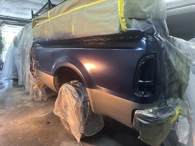 Masked pickup bed during paintwork inside the shop.