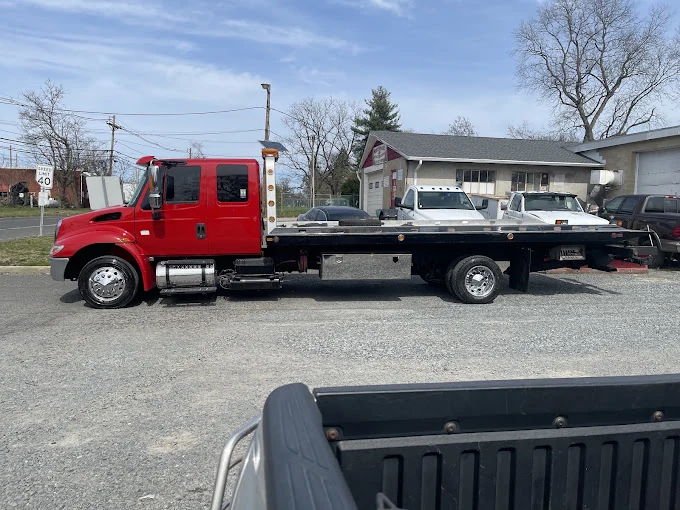 Red flatbed tow truck parked outdoors.